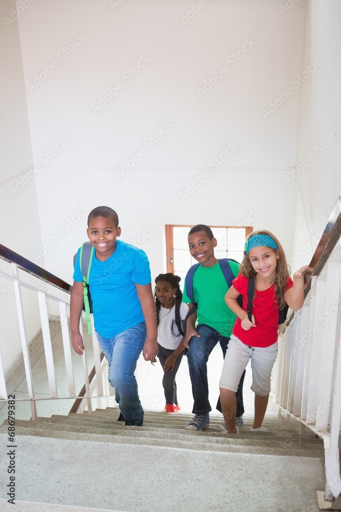 Cute pupils smiling and walking up stairs