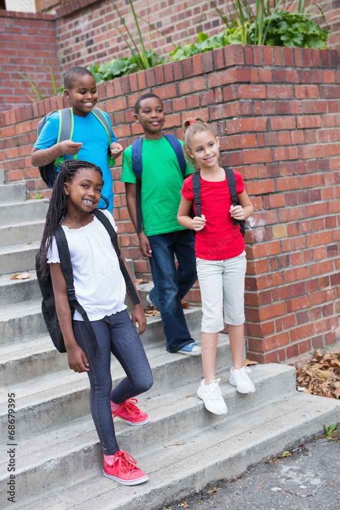 Fototapeta premium Cute pupils smiling on the stairs outside