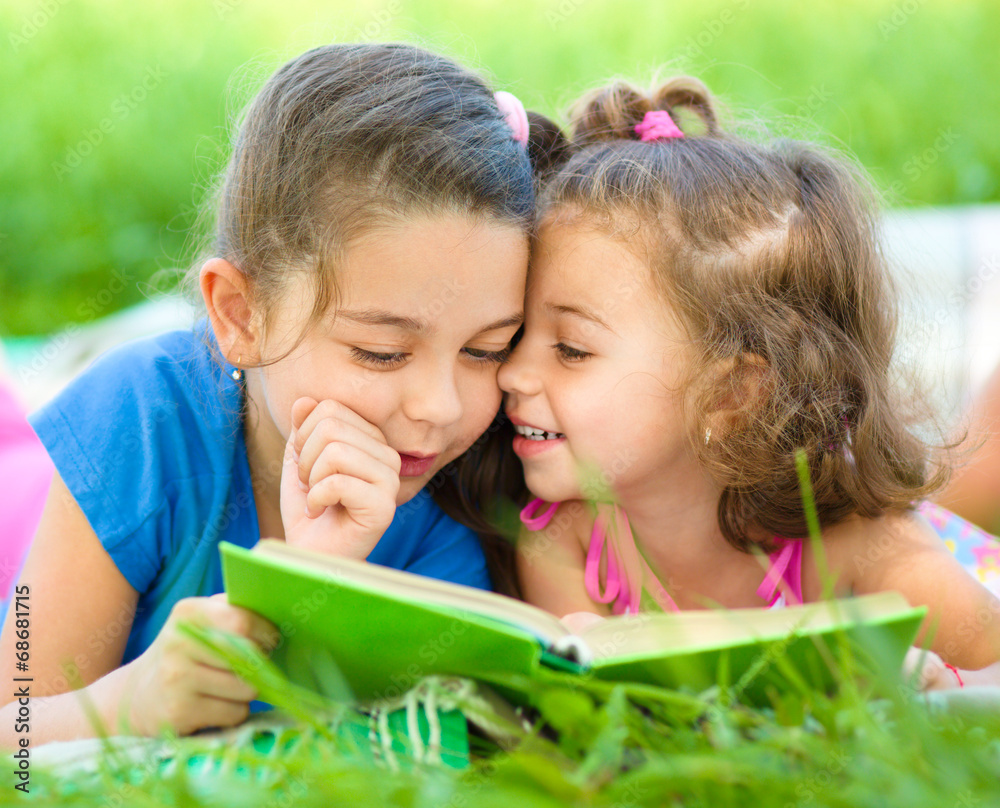 Two little girls are reading book Two little girls are reading book