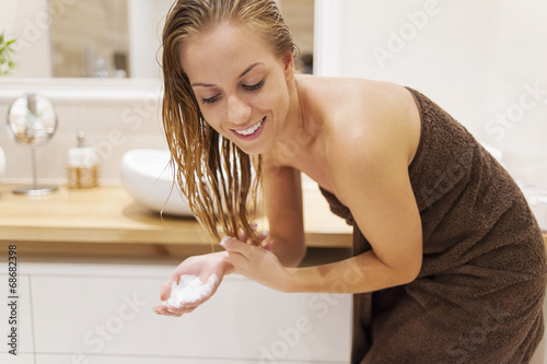 Woman applying conditioner after the shower