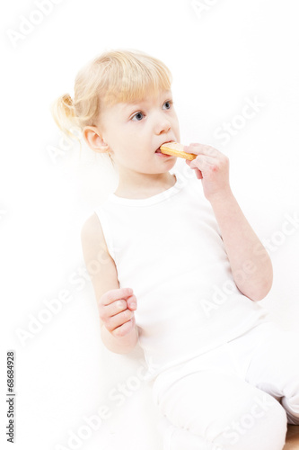 portrait of little girl eating buscuit photo