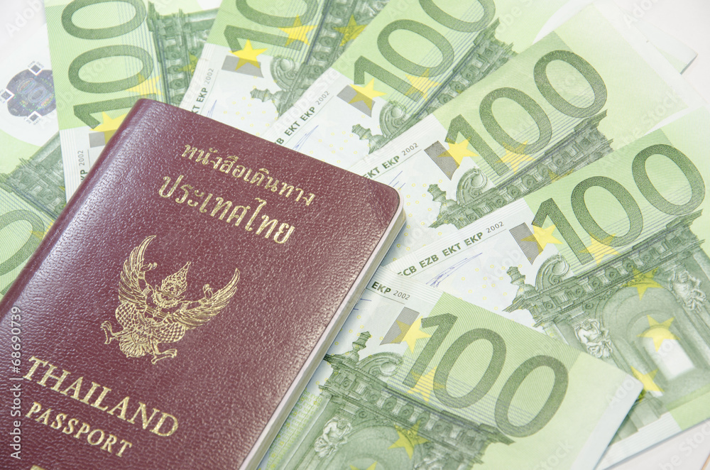 Close-up of 100 Euro banknotes and passport isolated on white ba Close-up of 100 Euro banknotes and passport isolated on white ba