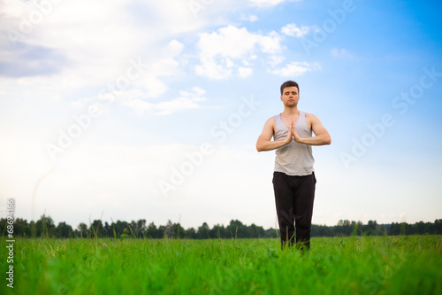 Young man doing yoga in park