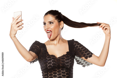 Tableau sur toile Funny girl make selfie and loll tongue
