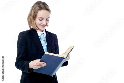 Small school girl reading a book