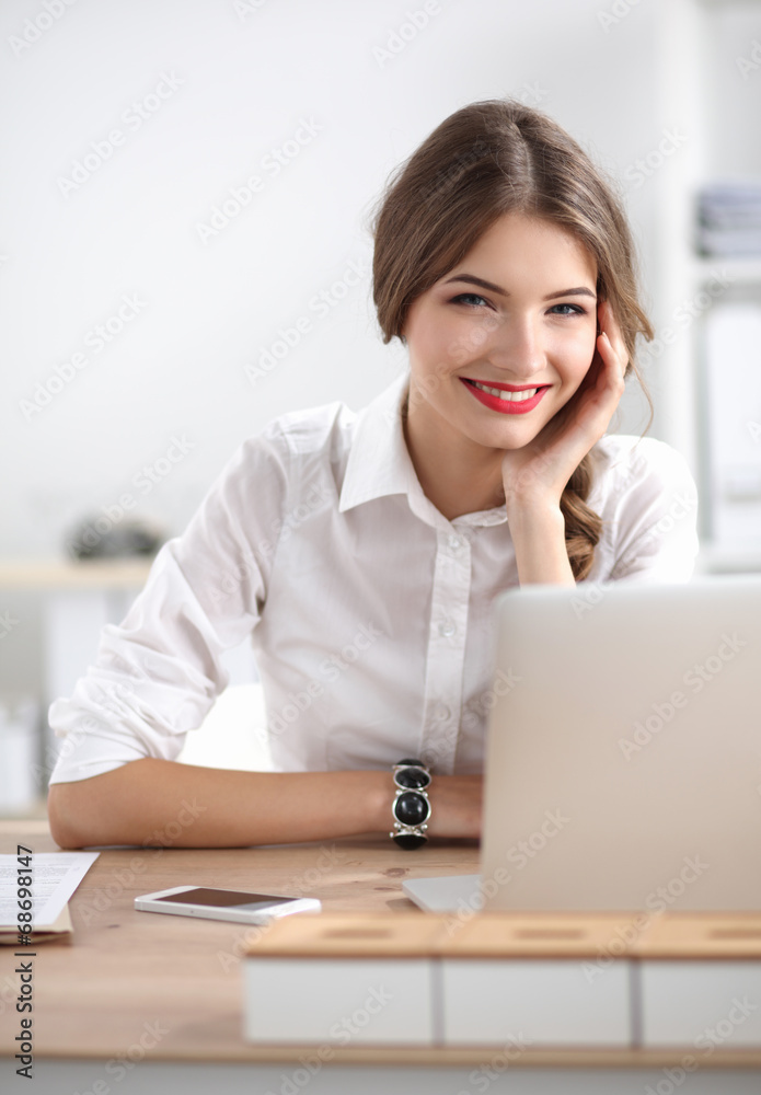 Attractive businesswoman sitting on desk in the office Attractive businesswoman sitting on desk in the office