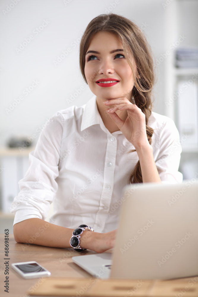 Attractive businesswoman sitting on desk in the office Attractive businesswoman sitting on desk in the office