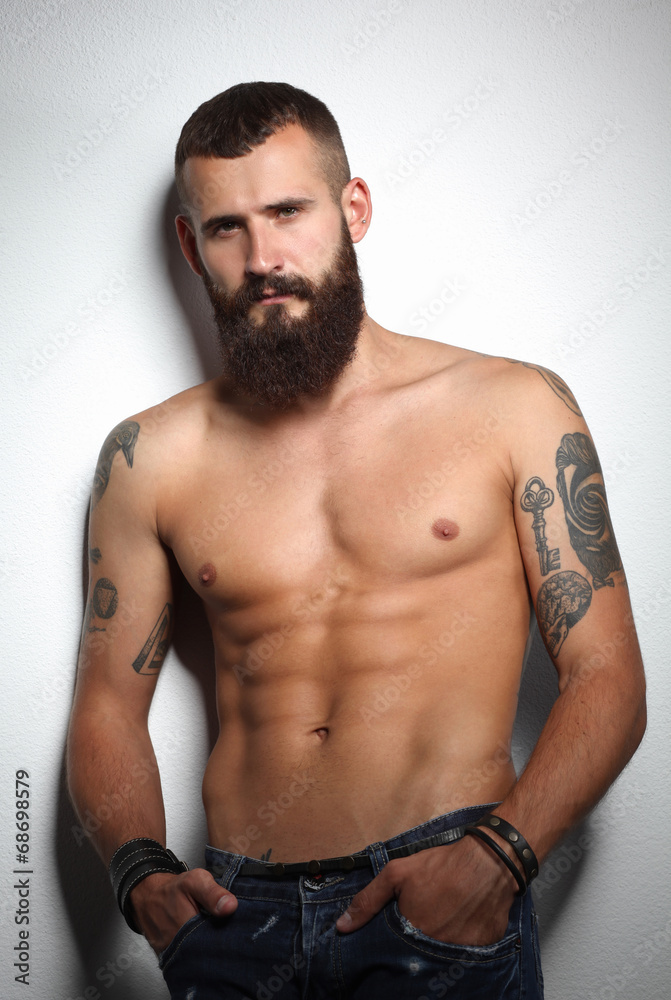 Portrait of handsome bearded man standing, isolated on grey