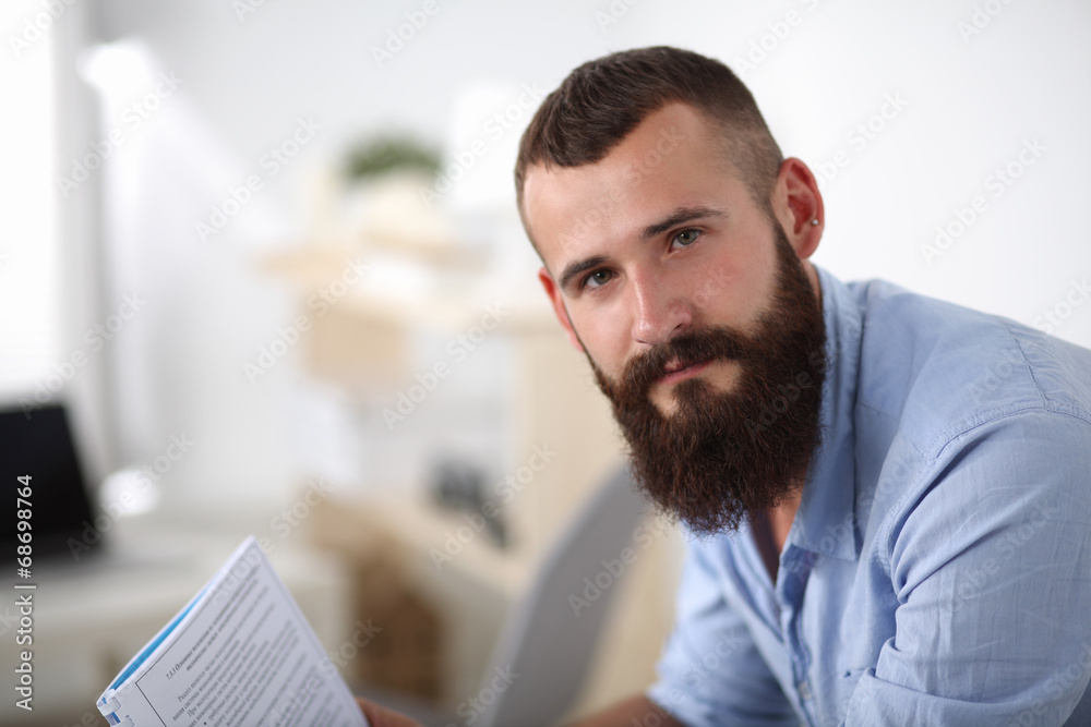Naklejka premium Young businessman sitting on chair in office