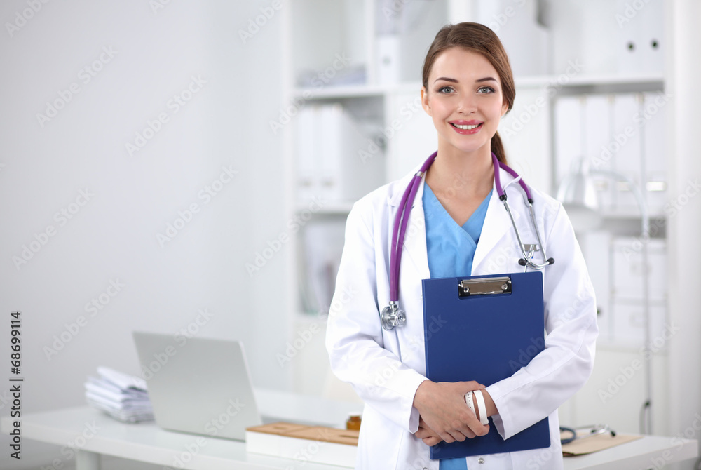 Smiling female doctor with a folder in uniform standing at Smiling female doctor with a folder in uniform standing at