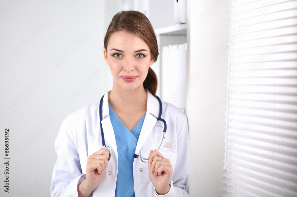 Woman doctor is standing near window Woman doctor is standing near window