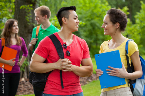Multi-ethnic students with folders and backpacks photo