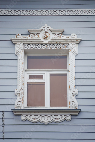 Window with wooden architrave in Russian national house