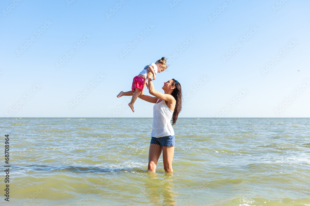 girl with mother on the beach by the sea girl with mother on the beach by the sea