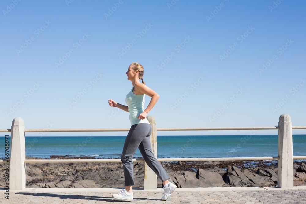 Fit mature woman jogging on the pier