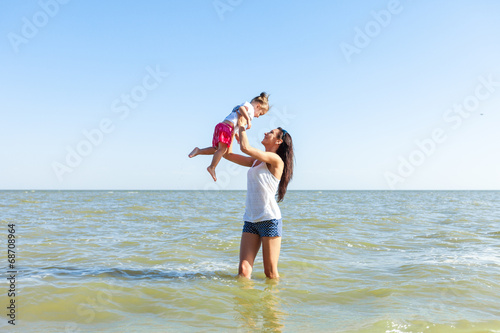 girl with mother on the beach by the sea