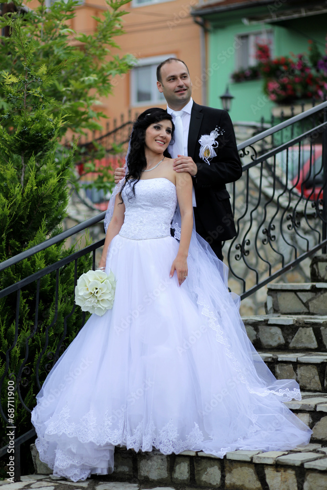 Fototapeta premium Young wedding couple posing on a staircase