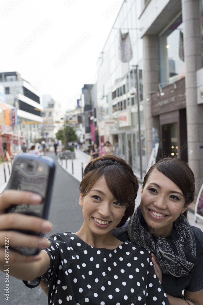 Women take a photograph on a mobile phone