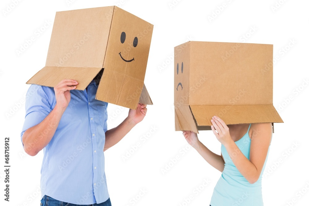 Couple wearing emoticon face boxes on their heads Couple wearing emoticon face boxes on their heads