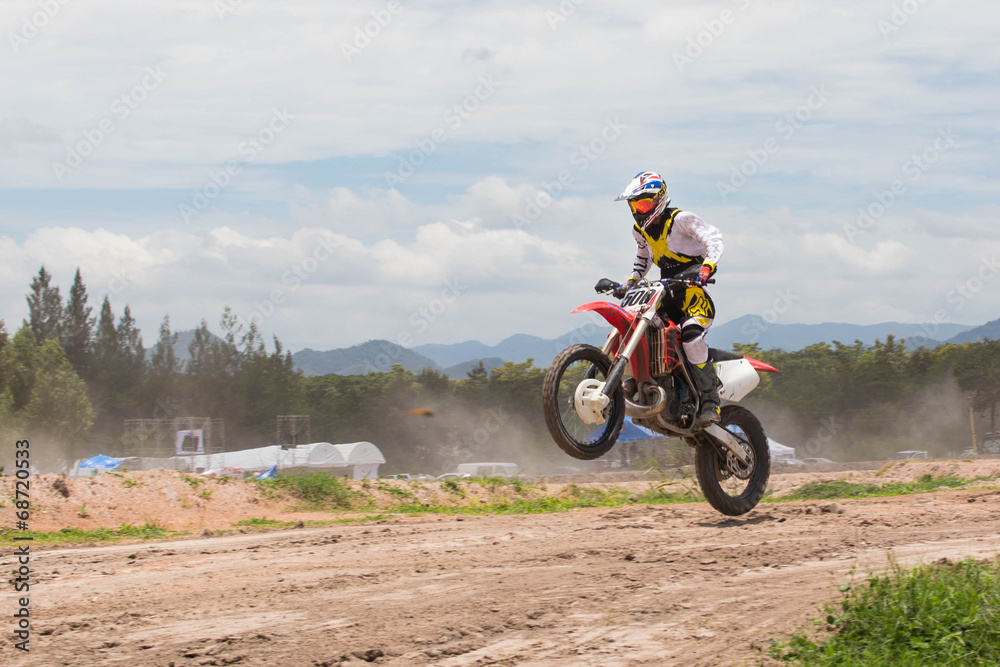 A picture of a biker making a stunt and jumps in the air