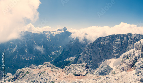 Panorama of a mountain valley partly covered with clouds