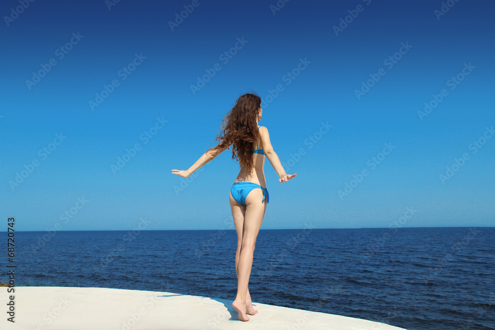 Enjoyment. Free brunette model woman in bikini over blue sky, ou