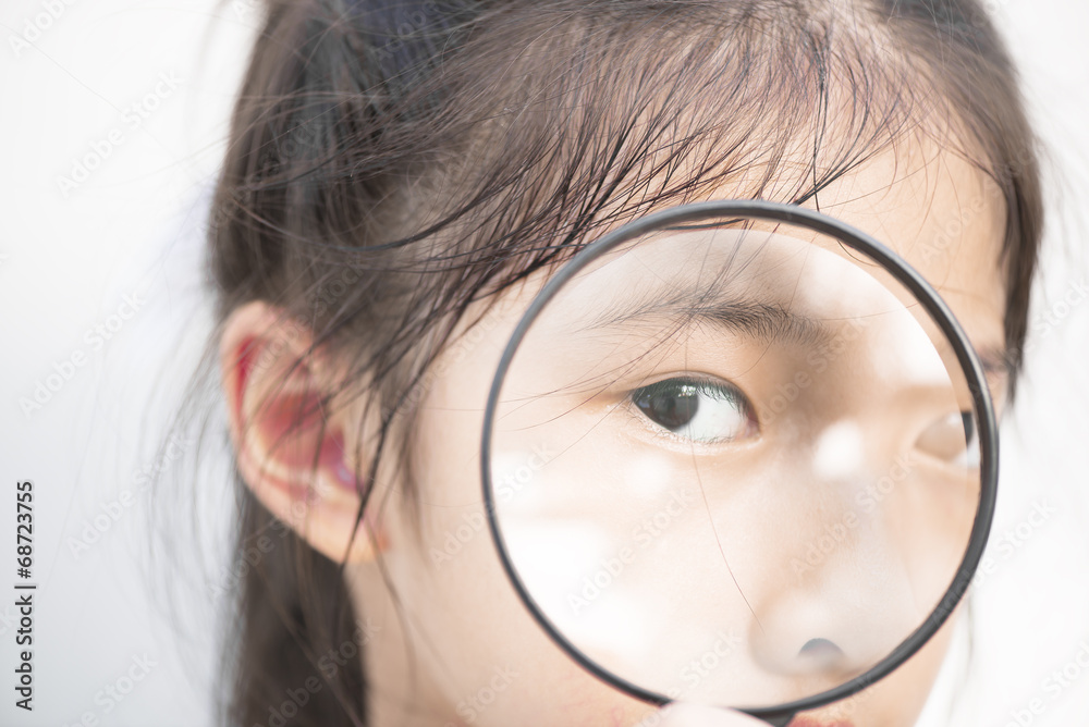 Little Asian girl looking through magnifier. Little Asian girl looking through magnifier.