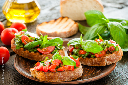 Italian bruschetta with chopped vegetables, herbs and oil on gr