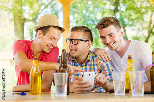 Friends drinking and using smartphone