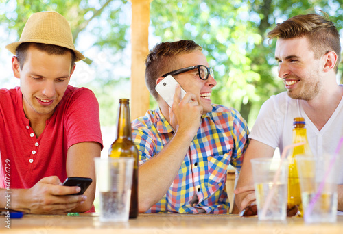 Friends drinking and using smartphone