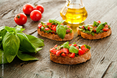 Italian bruschetta with chopped vegetables, herbs and oil on gr