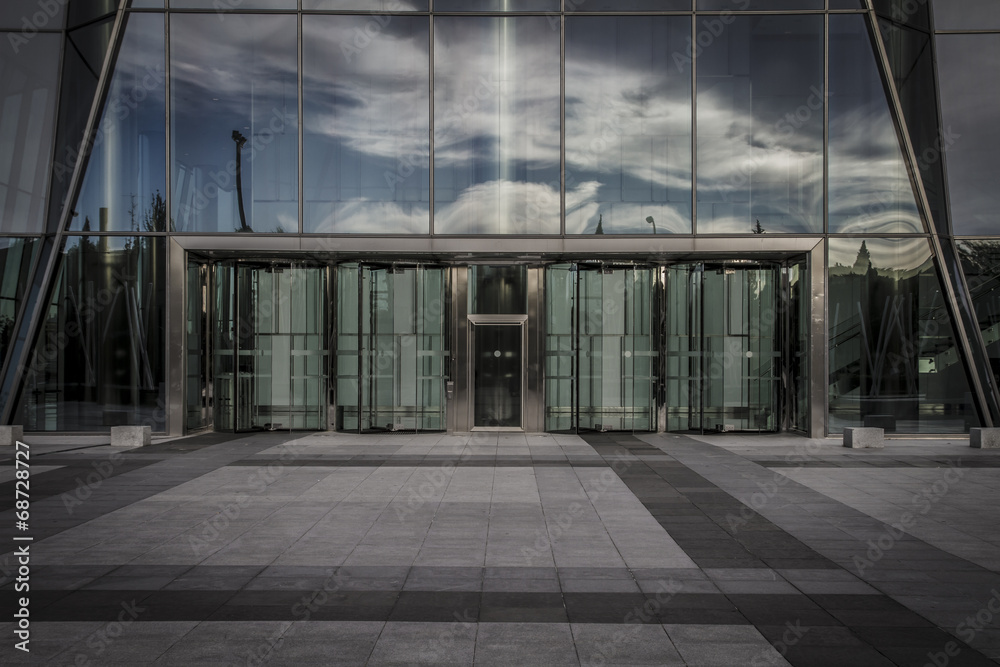 skyscraper with glass facade and clouds reflected in windows skyscraper with glass facade and clouds reflected in windows