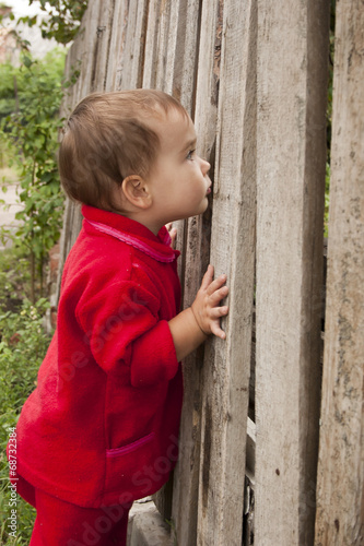 Ребёнок подглядывает за забор photo