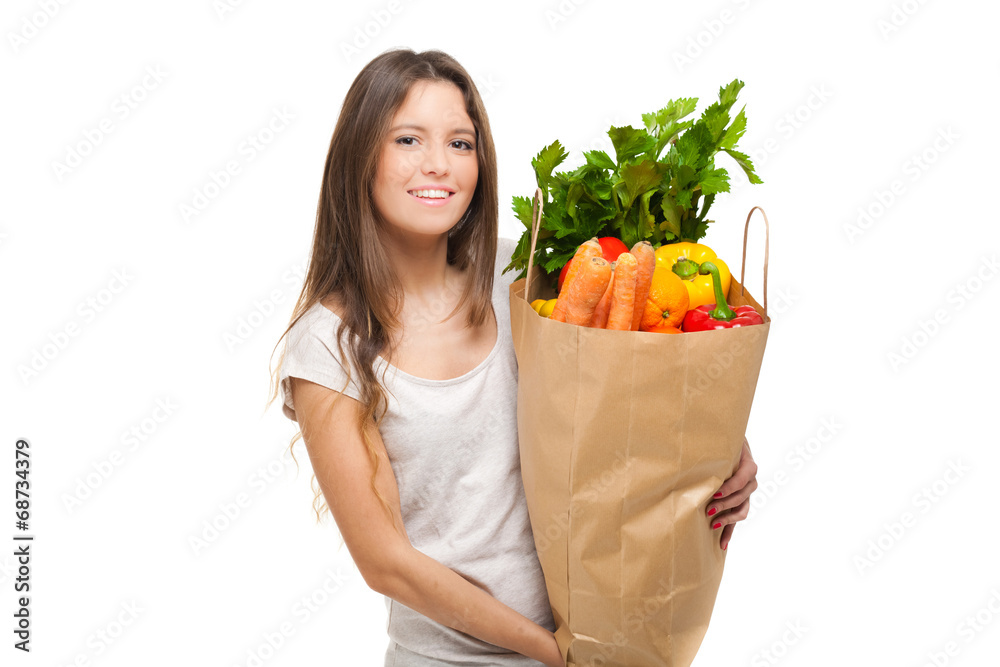 Young woman holding a bag full of vegetables Young woman holding a bag full of vegetables