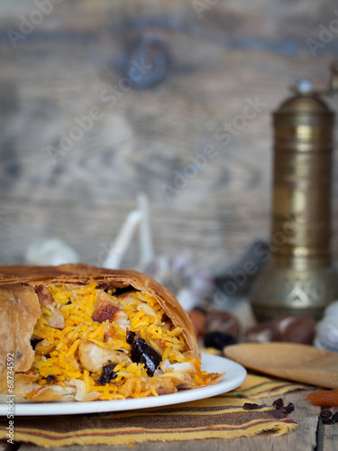 Pilaf in tortillas with dried fruits, garlic and burberry