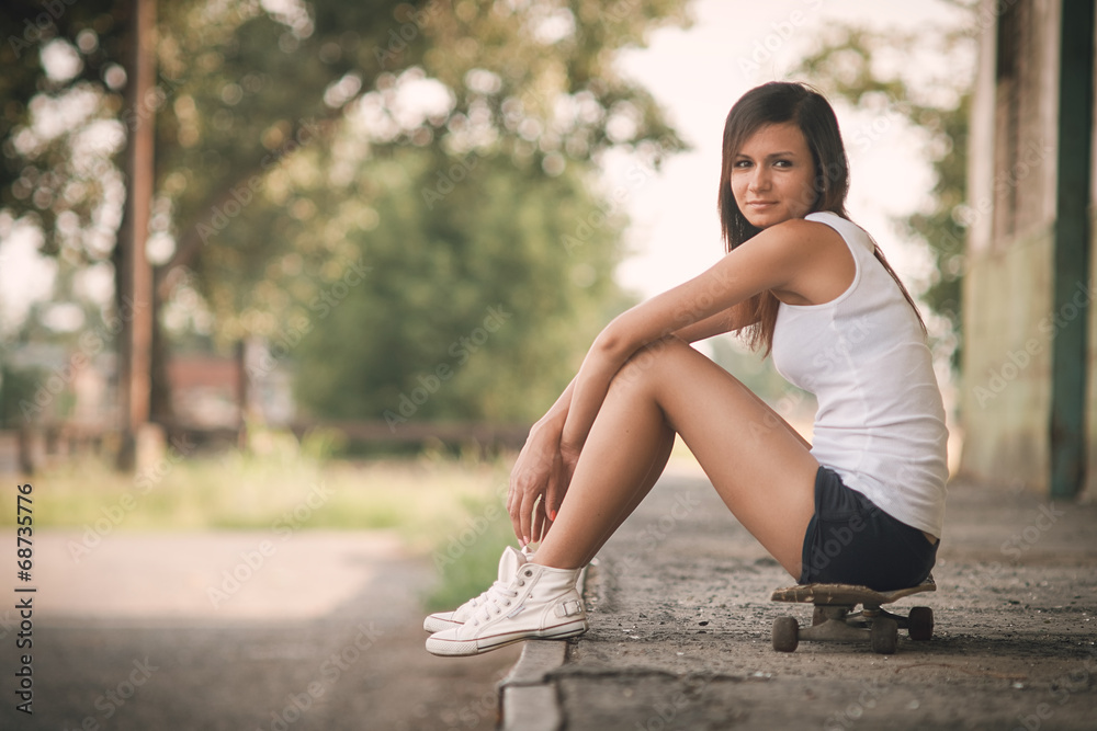 Beautiful skater girl in summer city