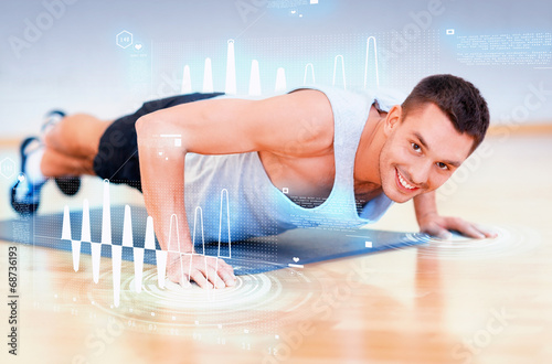 smiling man doing push-ups in the gym photo