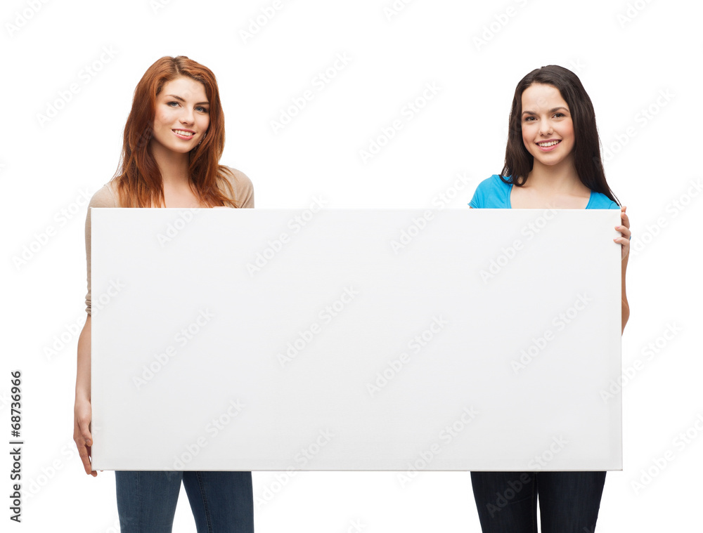 two smiling young girls with blank white board two smiling young girls with blank white board
