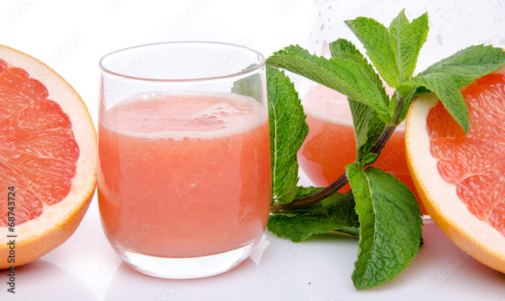 Glass of grapefruit juice with fresh grapefruits and mint Glass of grapefruit juice with fresh grapefruits and mint