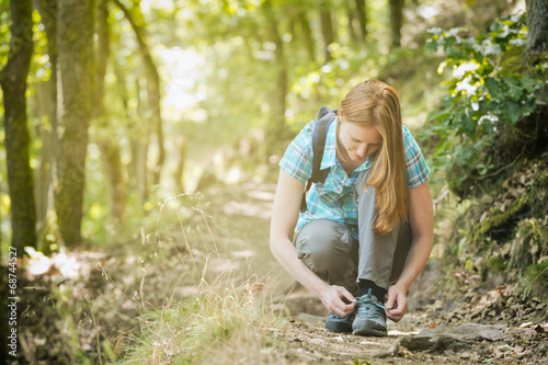Hiker Tying Her Shoe on a Trail