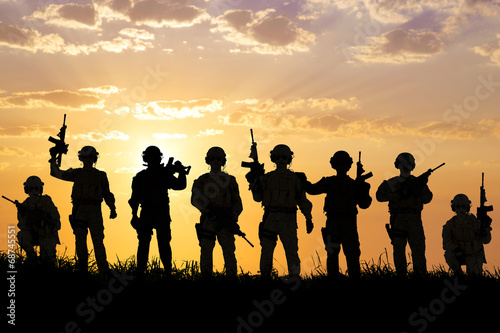 Konstfotografi silhouette of  Soldiers team with sunrise background