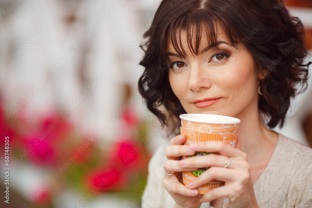 Young woman holding a paper cup and smiling Young woman holding a paper cup and smiling