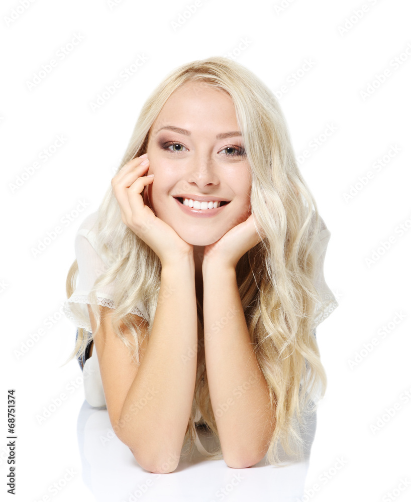 Beautiful blond teen girl lying, looking at camera and happy smi