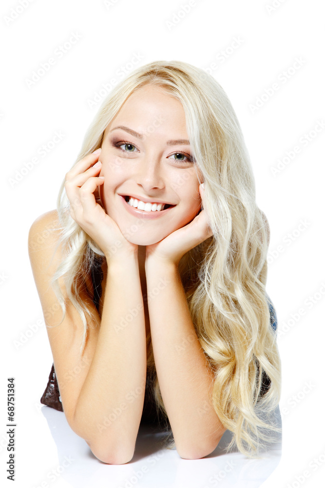 Beautiful blond teen girl lying, looking at camera and happy smi Beautiful blond teen girl lying, looking at camera and happy smi