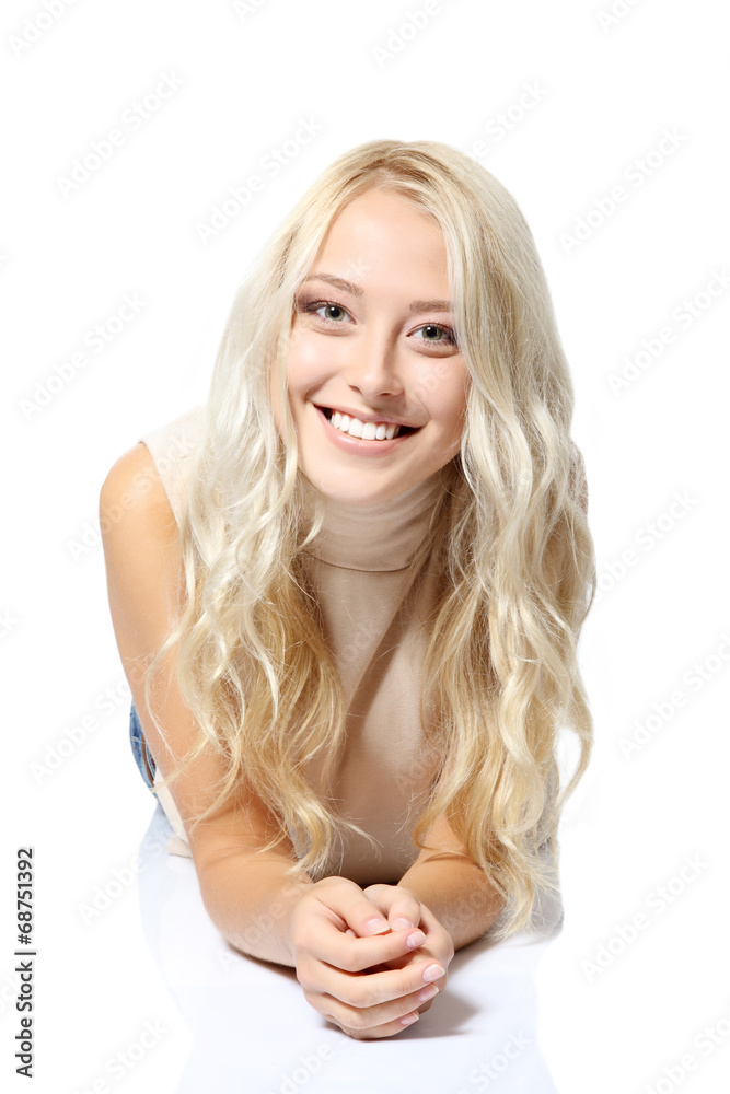 Beautiful blond teen girl lying, looking at camera and happy smi Beautiful blond teen girl lying, looking at camera and happy smi