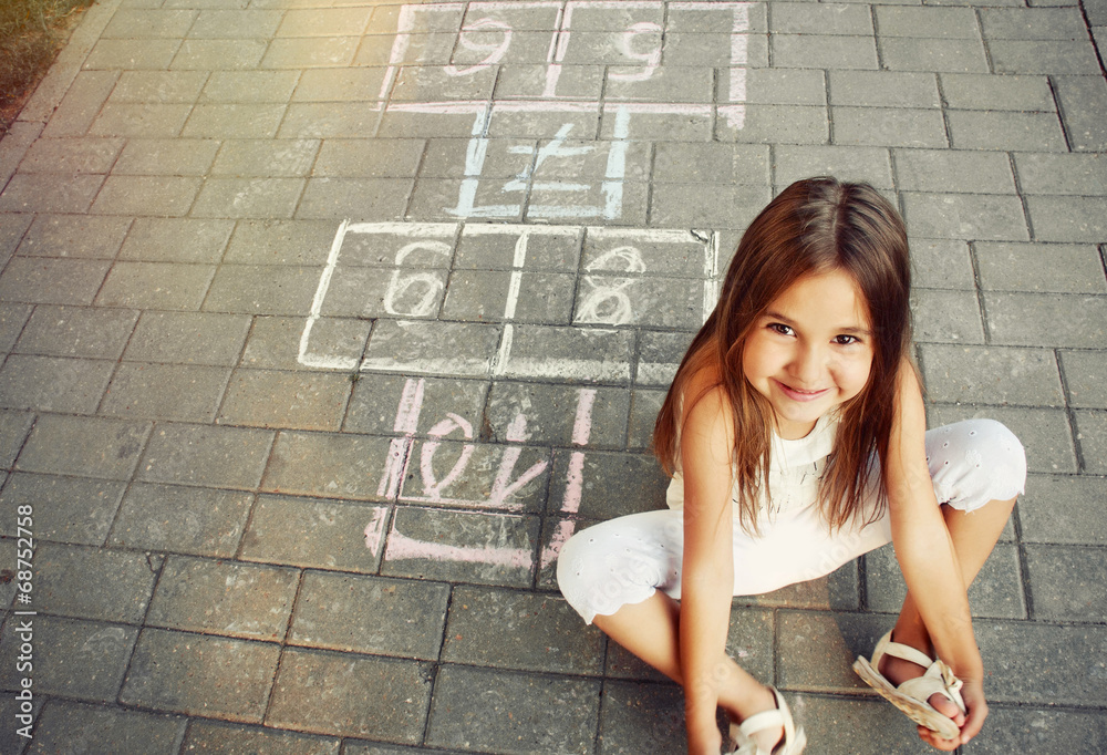 beautiful cheerful little girl playing hopscotch on playground - obrazy, fototapety, plakaty 