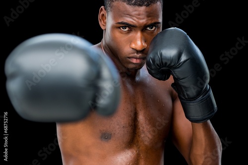 Young shirtless male boxer attacking with his right © WavebreakmediaMicro