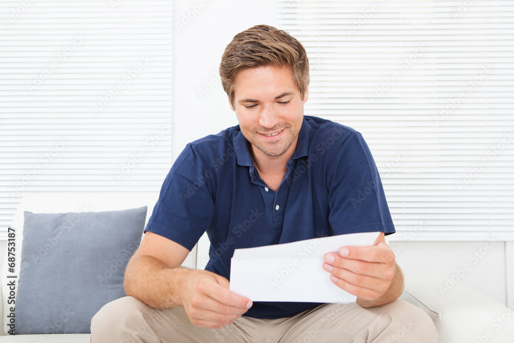 Smiling Man Reading Letter At Home Smiling Man Reading Letter At Home
