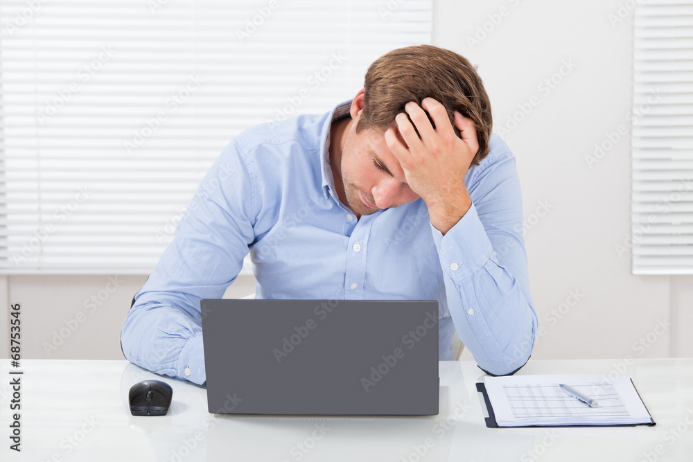Stressed Businessman Using Laptop In Office Stressed Businessman Using Laptop In Office
