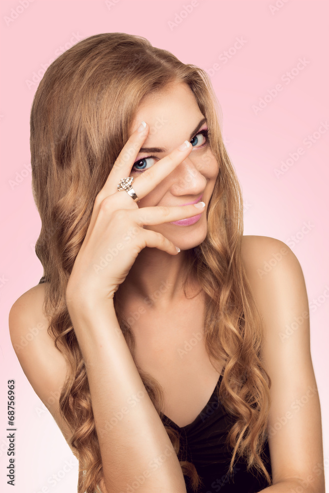 A beautiful young woman with a pink makeup looking through her f A beautiful young woman with a pink makeup looking through her f